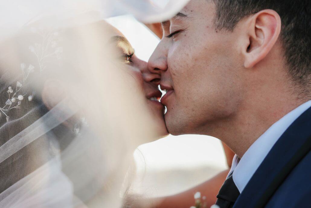 Houston wedding photography by Toast: close-up of a bride and groom about to kiss, with the bride wearing a veil and the groom in a suit.