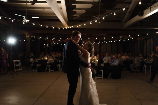 Bride and groom share their first dance under string lights at an Austin reception.