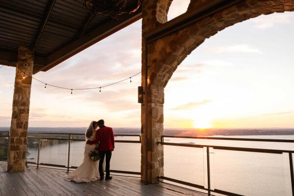 Austin wedding photography by Toast: bride and groom at sunset on a stone terrace above a lake.
