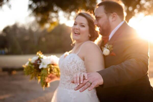 Bride and groom laugh at sunset as she shows her wedding ring, Austin wedding.
