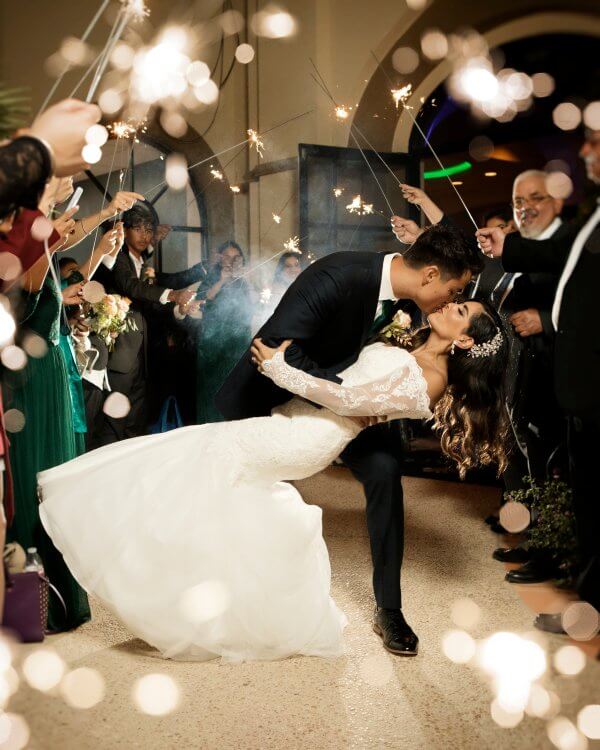 Bride and groom kiss during a sparkler exit at an Austin wedding.
