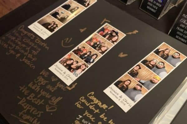 A scrapbook page with three photo booth strips of people posing, surrounded by handwritten congratulatory messages in gold marker.