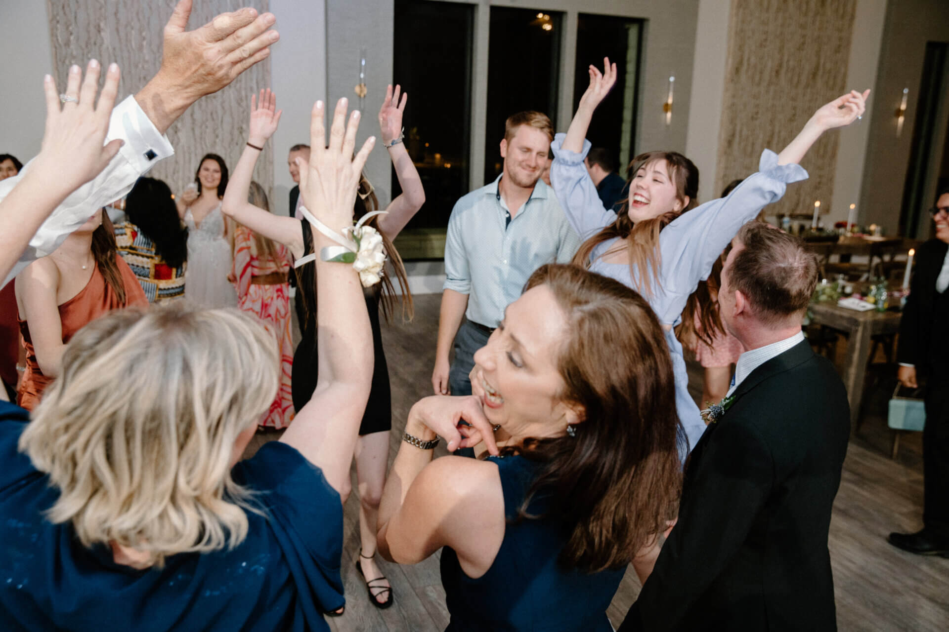 Wedding guests with hands raised on the Stonehouse Villa Reception Hall dance floor, Driftwood TX wedding venue