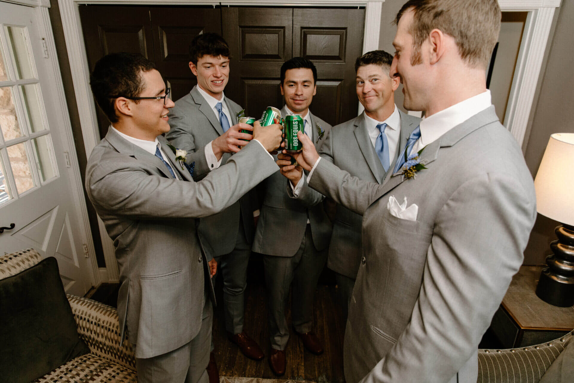 Groom and groomsmen toasting in the private Ready Room at Stonehouse Villa, Driftwood TX wedding venue