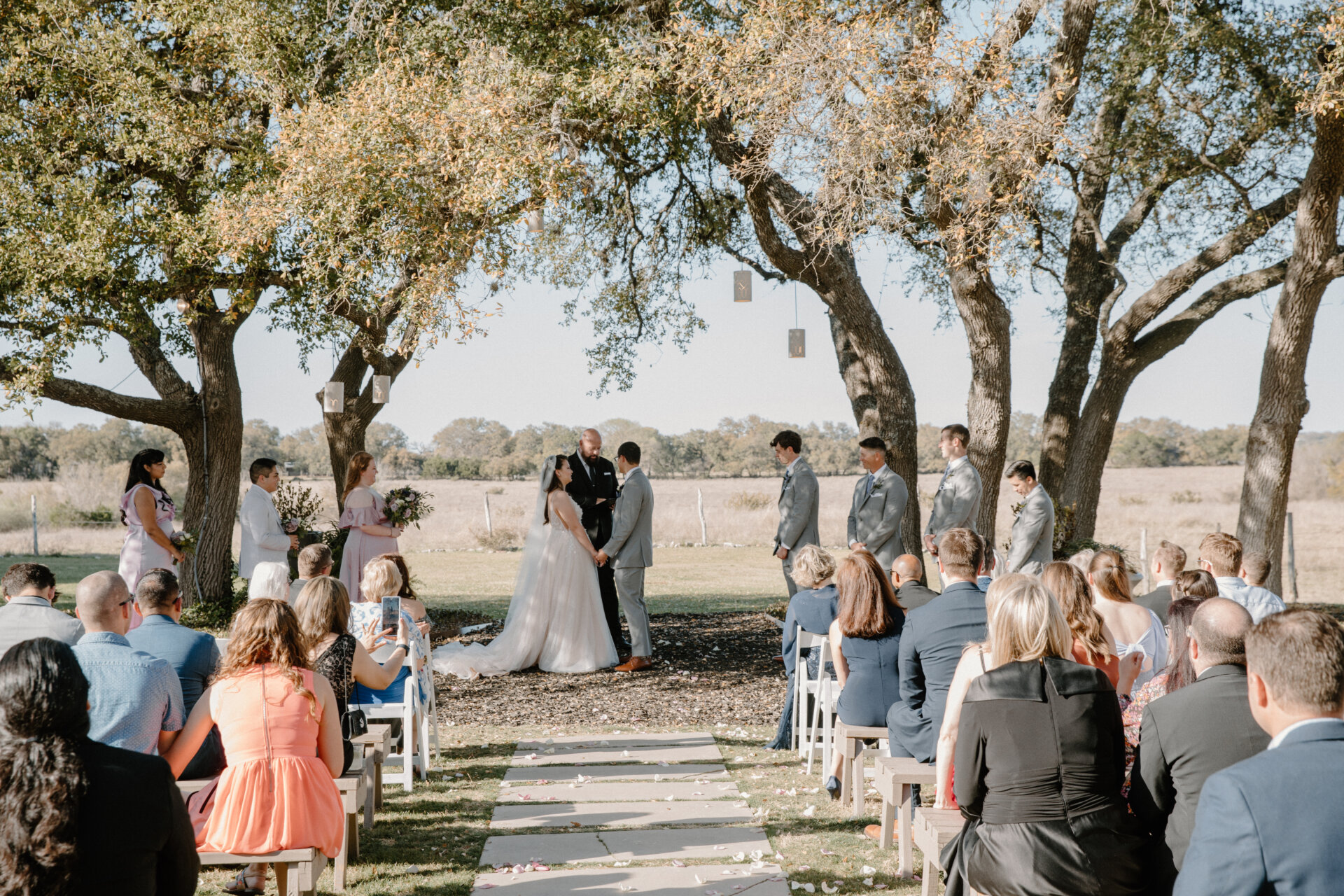 Stonehouse Villa Oak Tree Ceremony with guests seated under live oaks, Driftwood TX wedding venue